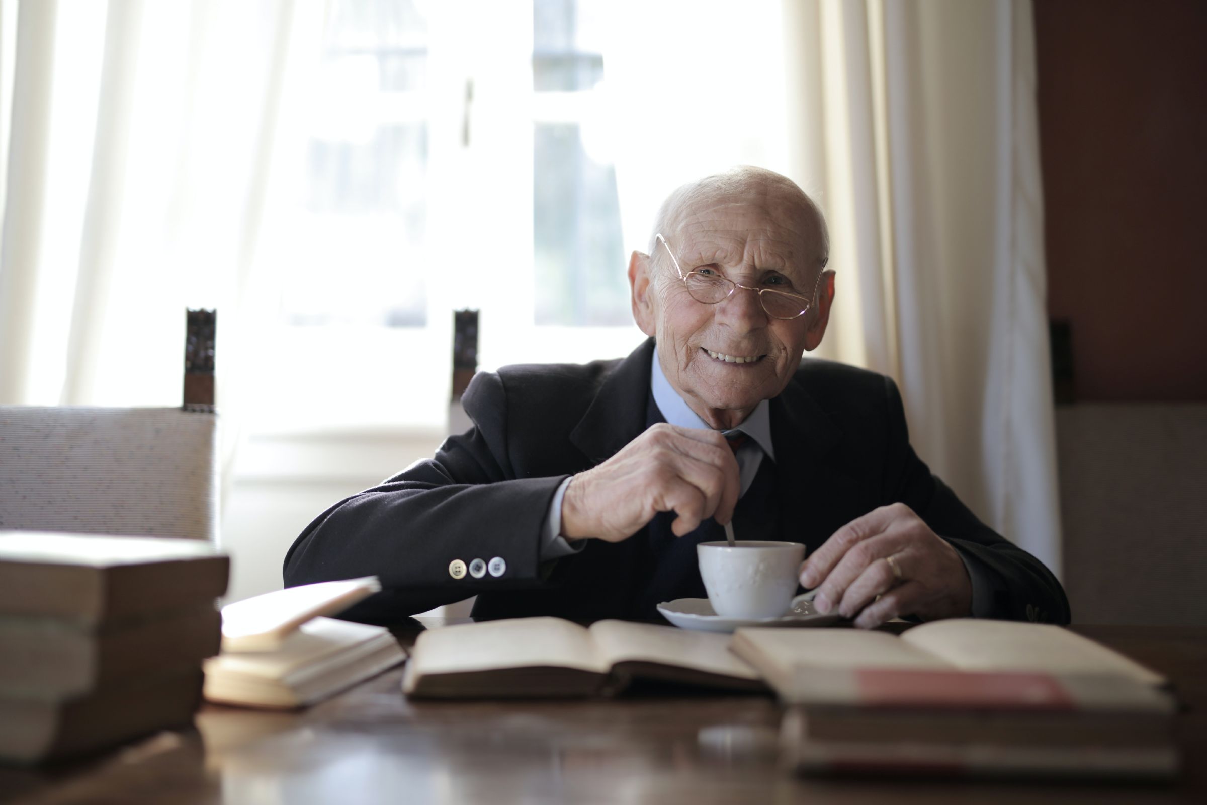 senior man in formal suit drinking